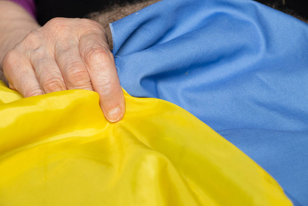 Ukrayna 'da Ukrayna Savaşı' nın bayrağı büyükannenin elinde, savaşı durdurun, protesto eylemi, barışçıl insanlar - Fotoğraf, Görsel