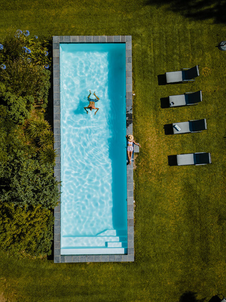 Drone view at swimming pool above with man and woman swimming Stellenbosch, near Cape Town, South Africa - 写真・画像