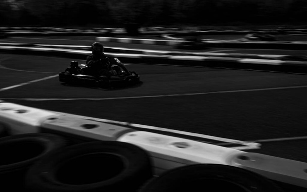 A panning shot of a racing kart as it circuits a track. - Foto, Imagen