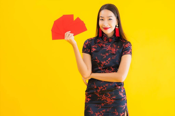 Ritratto bella giovane donna asiatica indossare abito cinese con Ang Pao o lettera rossa con contanti per il nuovo concetto cinese anno su sfondo giallo isolato
 - Foto, immagini