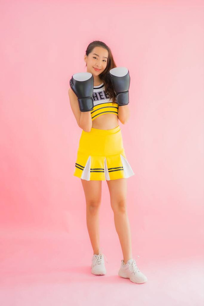 Portret piękny młody Azji kobieta cheerleaderka z boks akcja na różowy odizolowane tło - Zdjęcie, obraz