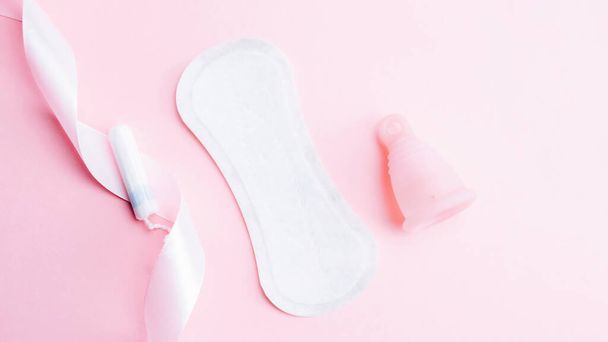 Menstrual cup, tampon, woman cup for sanitary protection. Pink ribbon with menstrual cup. Menstruation feminine period. Zero waste concept, ecofriendly lifestyle, reduced banner consumption - Photo, Image