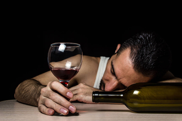El concepto de alcoholismo y adicción al alcohol. El hombre se durmió por intoxicación. Consumo excesivo de vino - Foto, imagen