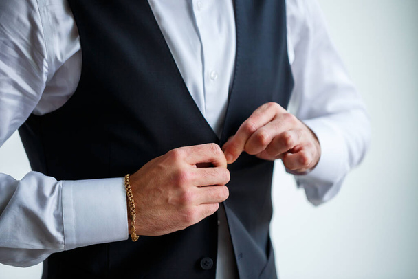 Молодой бизнесмен надевает рубашку и стильный костюм перед встречей - Фото, изображение