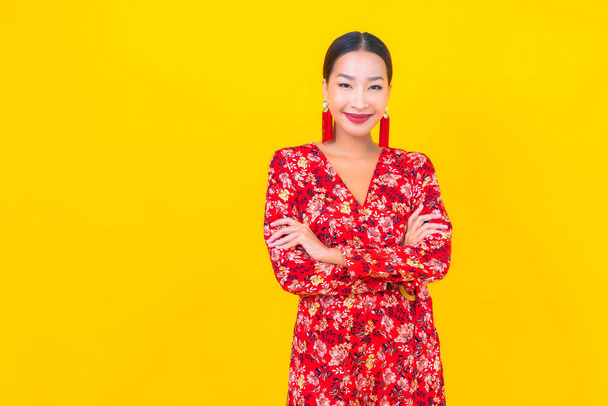 Retrato hermosa joven mujer asiática sonrisa en acción en chino nuevo concepto de año en el fondo de color - Foto, Imagen
