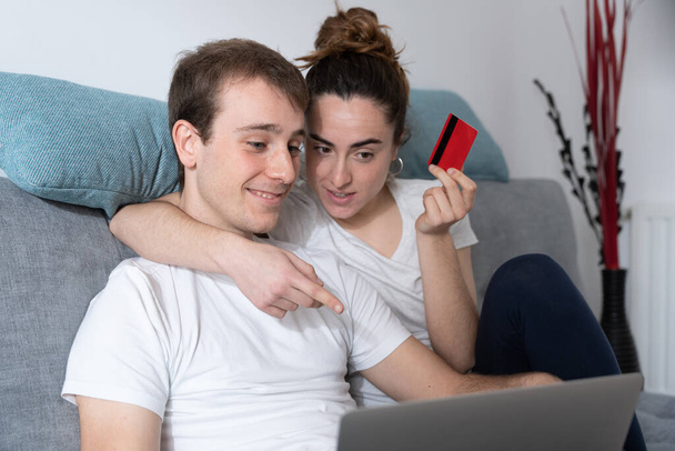 Νεαρό ζευγάρι επιλέγει προϊόν στο laptop. Έννοια online αγορών - Φωτογραφία, εικόνα