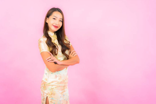 Ritratto bella giovane donna asiatica sorriso in azione con cinese nuovo concetto anno su sfondo di colore rosa - Foto, immagini