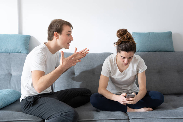 Digital addiction and cohabitation problems concept. Woman concentrated on social media ignoring boyfriend. - Photo, Image