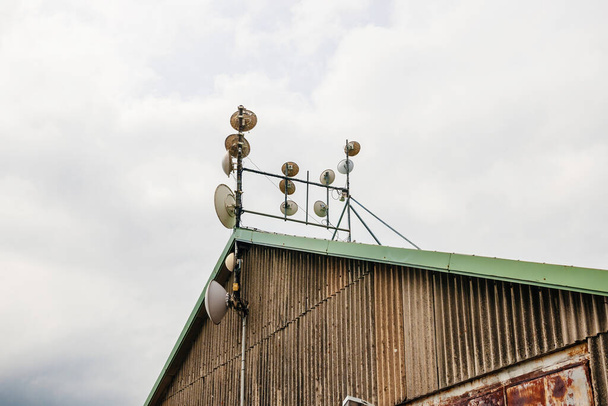 Вид збоку декількох антен комунікатону на стовпі даху щогли
 - Фото, зображення