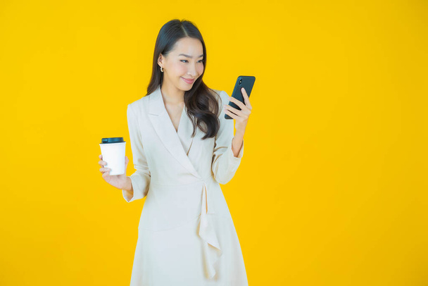 Портрет красивая молодая азиатская женщина улыбка со смартфона на цветном фоне - Фото, изображение