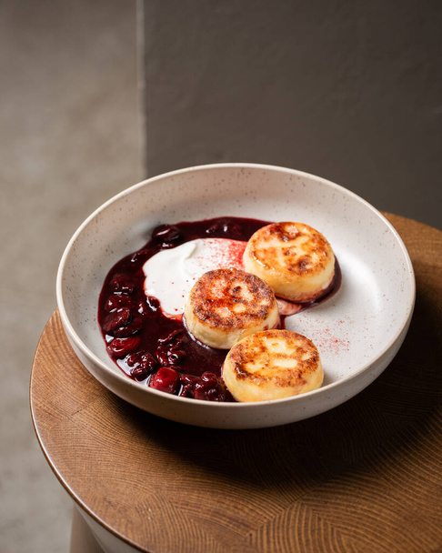 Cottage cheese pancakes, cherry sauce and yogurt ( syrniki ) - Photo, Image