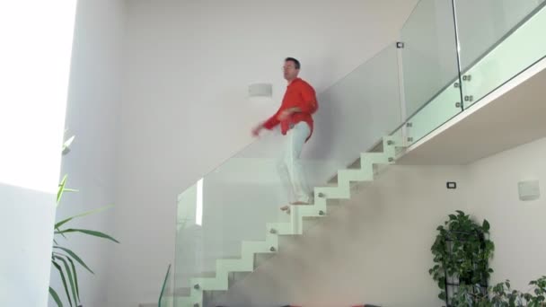 Одинокий дорослий чоловік в приміщенні вдома танцює, йдучи вниз по сходах з ентузіазмом розважається - весело, свобода, емоційна концепція
 - Кадри, відео