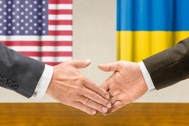 Des représentants des Etats-Unis et de l'Ukraine se serrent la main - Photo, image