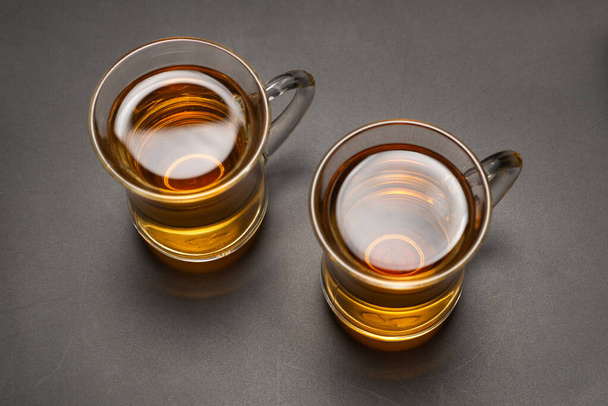 Un vaso de té turco sobre un fondo negro. - Foto, Imagen