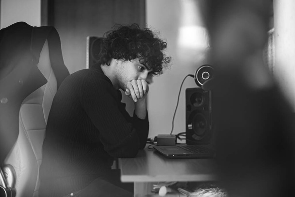 Umsichtiger Musiker an seinem Produktionstisch. Bild in Schwarz-Weiß. - Foto, Bild