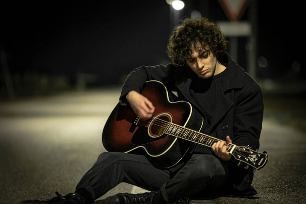 Musician with Acoustic Guitar alone in the Sidewalk at night - Φωτογραφία, εικόνα