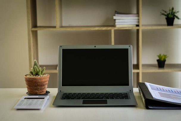 Laptop computer, rekenmachine en financiële grafiek document op bureau van de zakenman. - Foto, afbeelding
