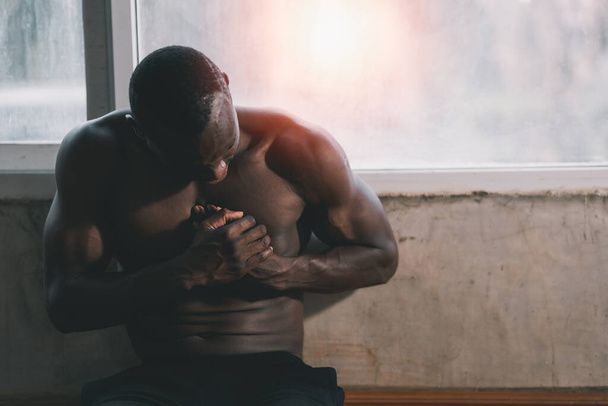Hombre africano atleta que tiene dolor en el pecho debido a enfermedades del corazón, Después de hacer ejercicio en el gimnasio. Concepto de salud. - Foto, Imagen