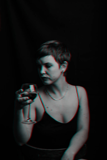 mooi jong meisje probeert en evalueert rode wijn. Zwart-wit met glitch-effect - Foto, afbeelding