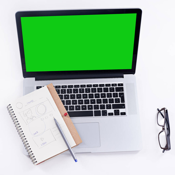 Werkzeuge, um die Aufgabe zu erledigen. Aufnahme eines Laptops mit grünem Bildschirm. - Foto, Bild