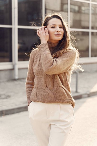 Elegant woman in a brown sweater in a spring city - Foto, afbeelding