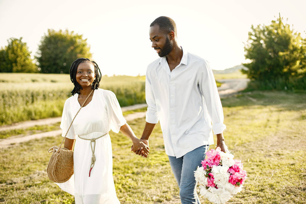 African newlyweds walking with bouquet in nature - Photo, Image