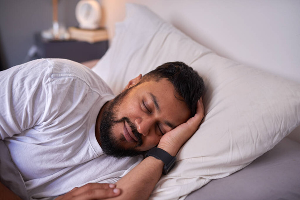 Dospělý muž spí klidně s úsměvem v posteli ráno - Fotografie, Obrázek