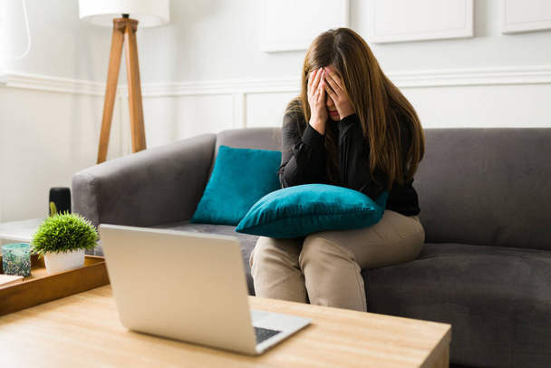 Καταθλιπτική νεαρή γυναίκα κλαίει ενώ μιλάει για τα προβλήματά της κατά τη διάρκεια μιας εικονικής συνεδρίας θεραπείας  - Φωτογραφία, εικόνα