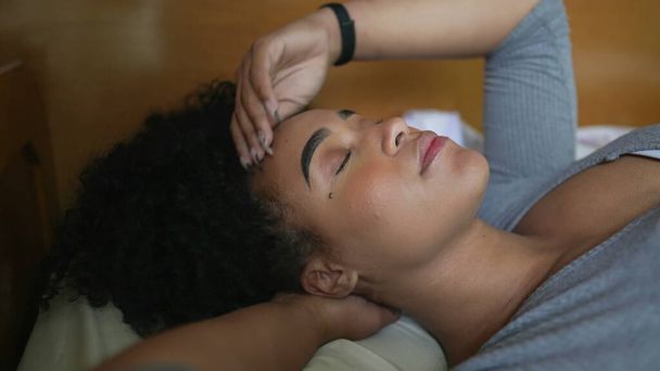 Задумчивая женщина в постели, играющая с волосами отдыха - Фото, изображение