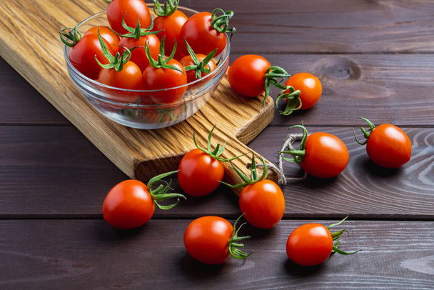 Rode tomaat in glazen schaal op houten tafel. Biologisch gezond voedsel. Ingrediënten koken. Pomodoro op het bureau - Foto, afbeelding