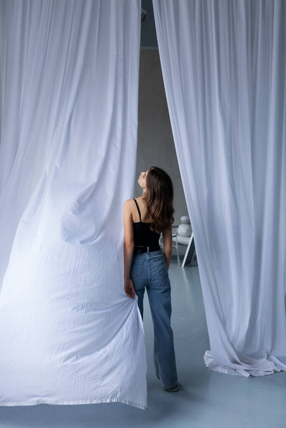 slender girl in light jeans and a black  top - Fotografie, Obrázek