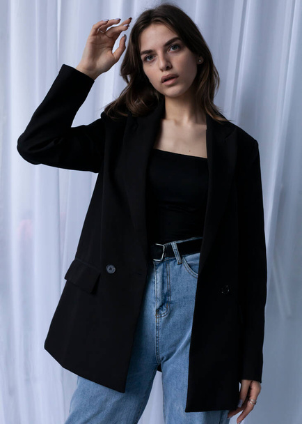 beautiful girl posing in a black spring jacket - Fotó, kép