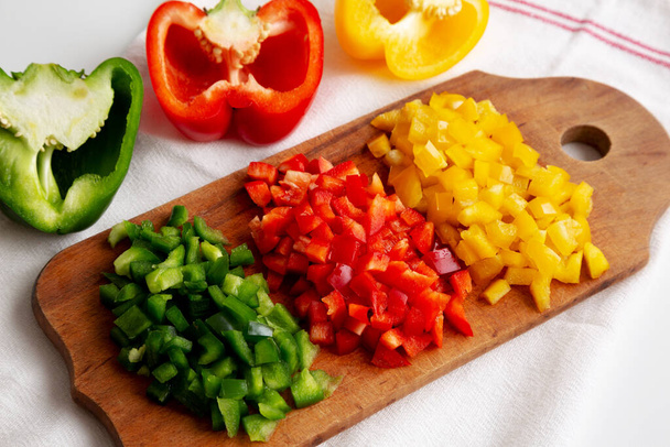 Chopped Fresh Colored Peppers on a Rustic Wooden Board, side view.  - Photo, Image