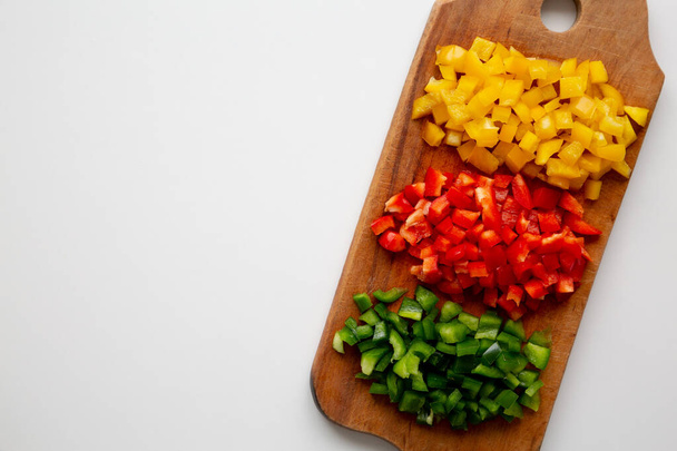 Chopped Fresh Colored Peppers on a Rustic Wooden Board, top view. Flat lay, overhead, from above. Space for text. - Photo, Image