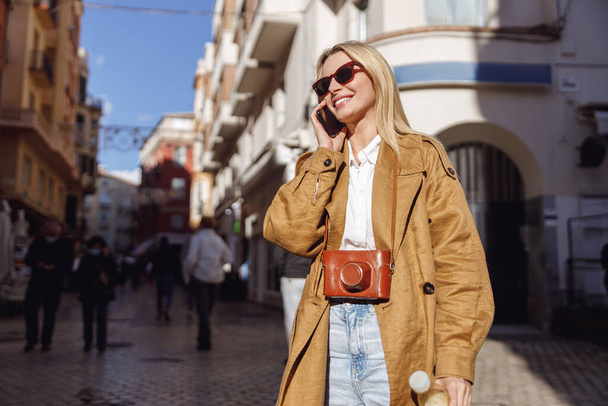 Портрет женщины, звонящей по телефону на улице - Фото, изображение