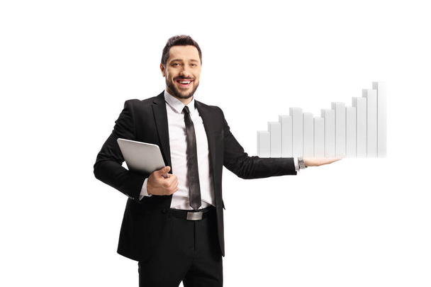 Businessman holding a tablet and presenting a bar chart isolated on white background - Foto, Imagem