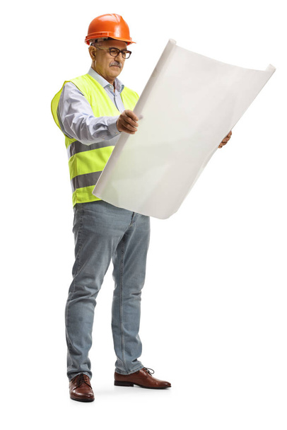 Full length portrait of a male engineer standing and reading a blueprint isolated on white background - Foto, immagini