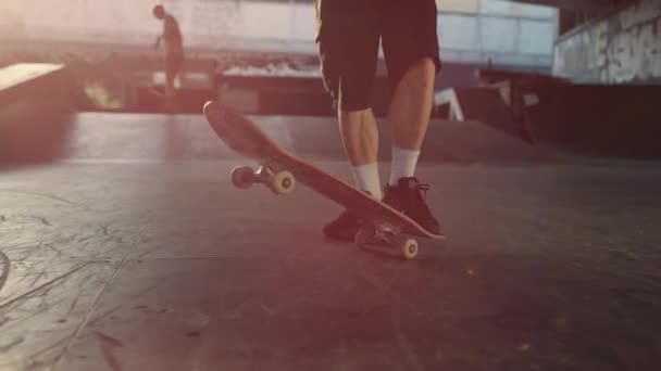 Hombre activo practicando skate en skate park con graffiti en la pared.  - Metraje, vídeo