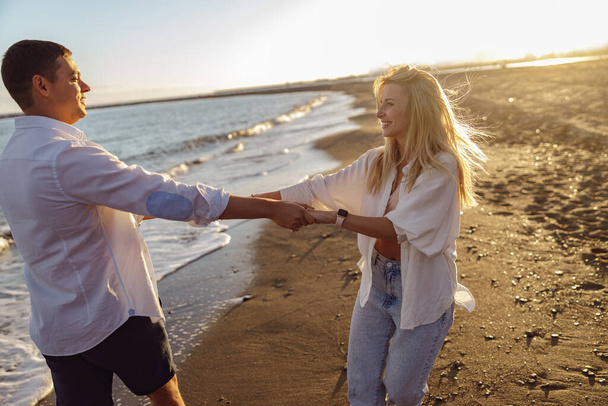 Jeune couple profitant de la soirée sur la plage ensemble - Photo, image