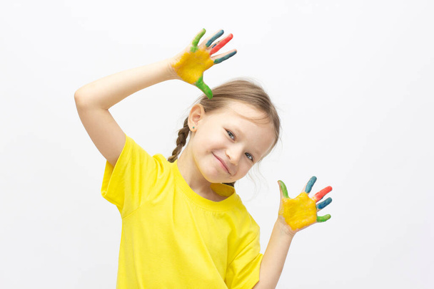 Happy cute little girl with colorful painted hands isolated on a white education concept - Foto, Bild
