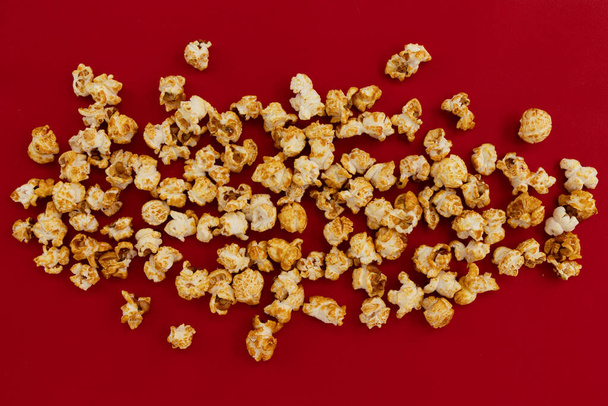 frame of caramel popcorn and empty space for text on red background, sweet snacks - Photo, image