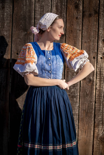 Young beautiful slovak woman in traditional dress posing outdoors. Slovak folklore - Photo, Image