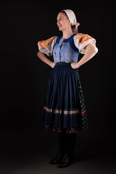 Nuori kaunis laiska nainen perinteisessä mekossa poseeraa mustalla taustalla. Slovakian kansanperinne - Valokuva, kuva