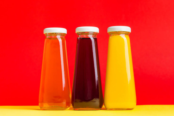 Sarı ve kırmızı sıvı halli içecekler sarı ve kırmızı arka planda. Turuncu elmalı kiraz - Fotoğraf, Görsel