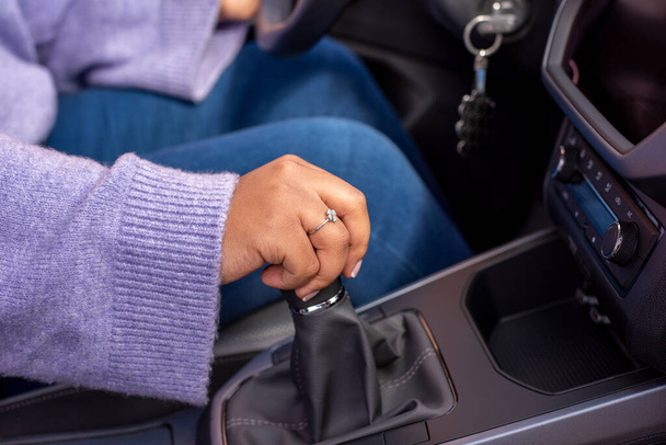 Close up Young woman hand on manual gear shift, shifting gearbox in car.Driver woman hand holding manual transmission or variable speed drive in car, shifting gear stick before driving car.  - Φωτογραφία, εικόνα
