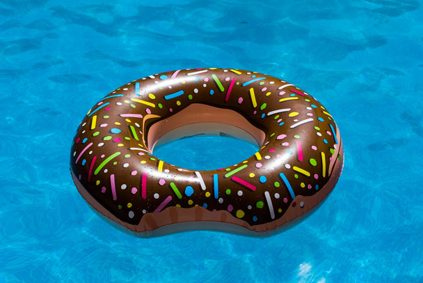 Donut lifeline thrown into the blue pool. - Zdjęcie, obraz
