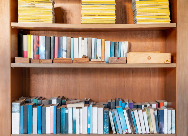 Bücher im Bücherregal im Wohnzimmer für den Besitzer zum Entspannen und Lesen in der Freizeit, Für Bildung und Aktivitätskonzept. - Foto, Bild