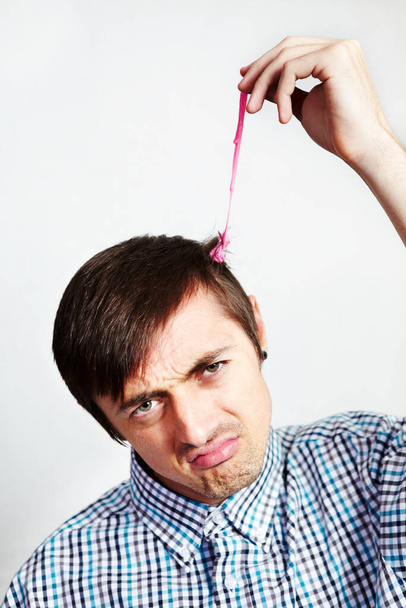 C'est une situation délicate. Portrait d'un homme mécontent avec du chewing-gum dans les cheveux. - Photo, image