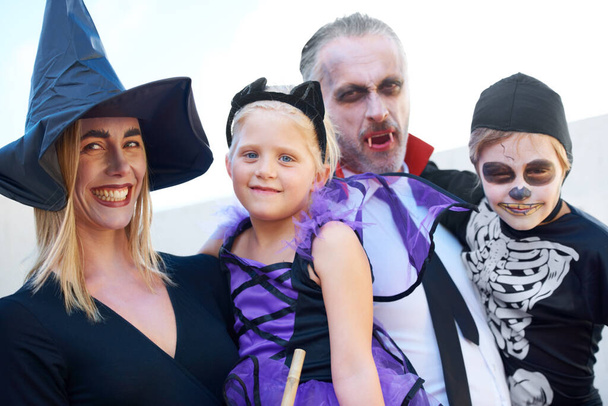 Портрет семьи Хэллоуин. Веселая семья, наряженная на Хэллоуин, позирующая вместе. - Фото, изображение