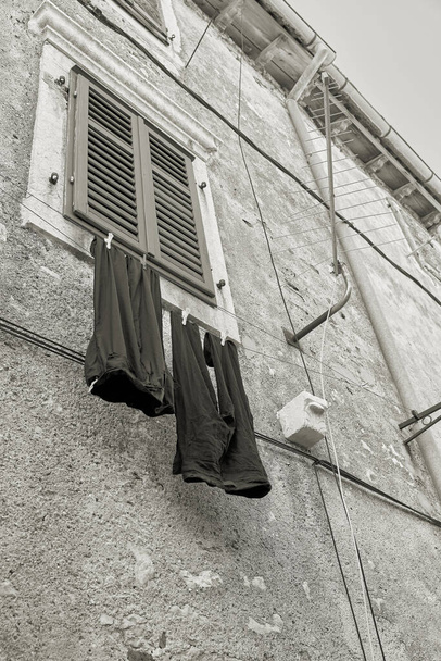  Шкаф с брюками на фасаде в старом городе Крк в Хорватии                               - Фото, изображение